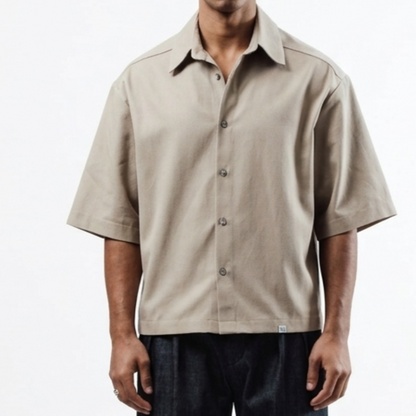 Beige short-sleeve shirt worn by a person on a white background